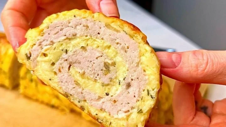 Roulade di pollo e formaggio appena sfornato su un piatto decorato.