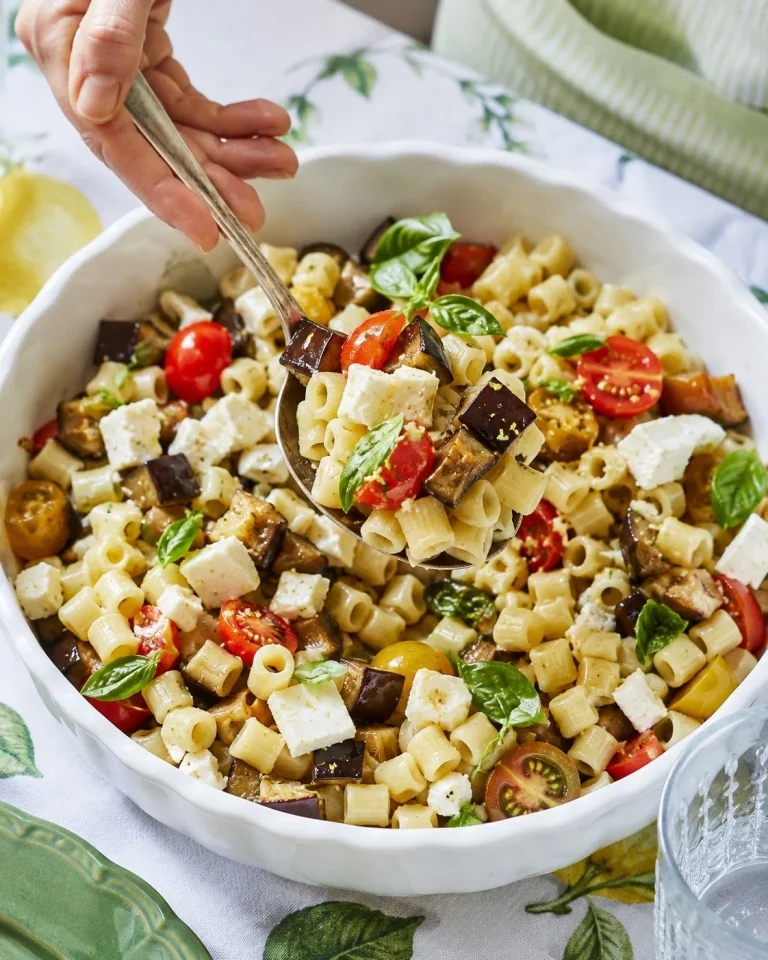 Pasta fredda con melanzane, pomodorini e primo sale servita in un piatto